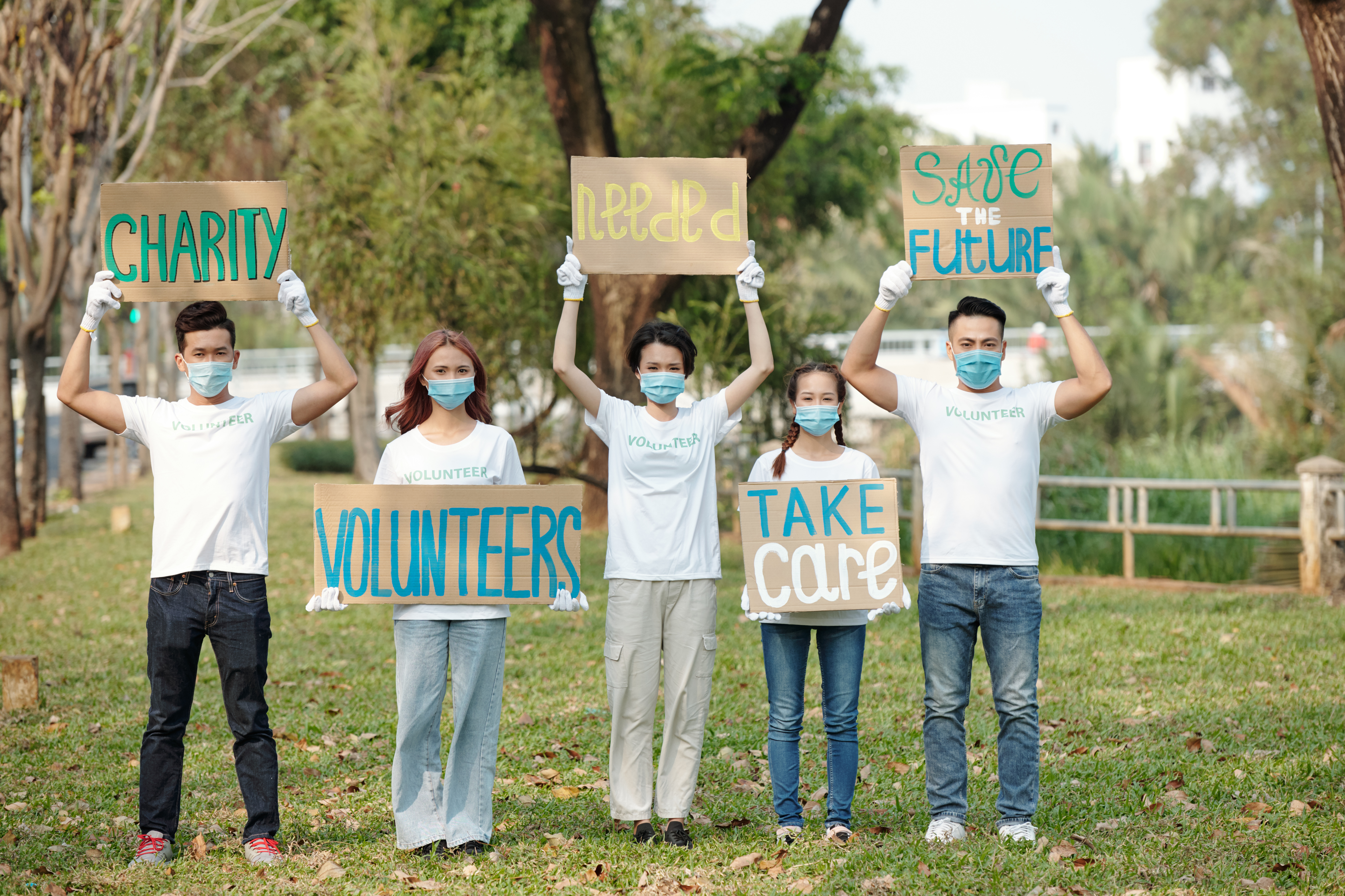 Volunteers Protesting with Placards Group of young volunteers protesting with various placards in city park